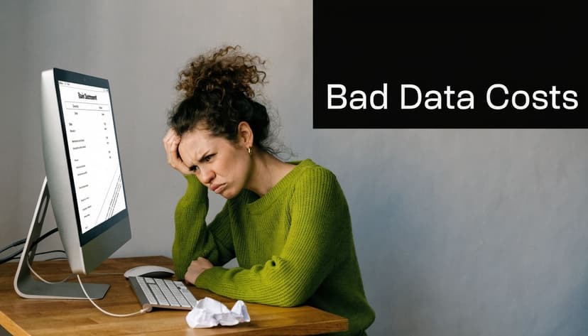 A woman in a green sweater looks stressed while looking at a bank statement on her computer screen.